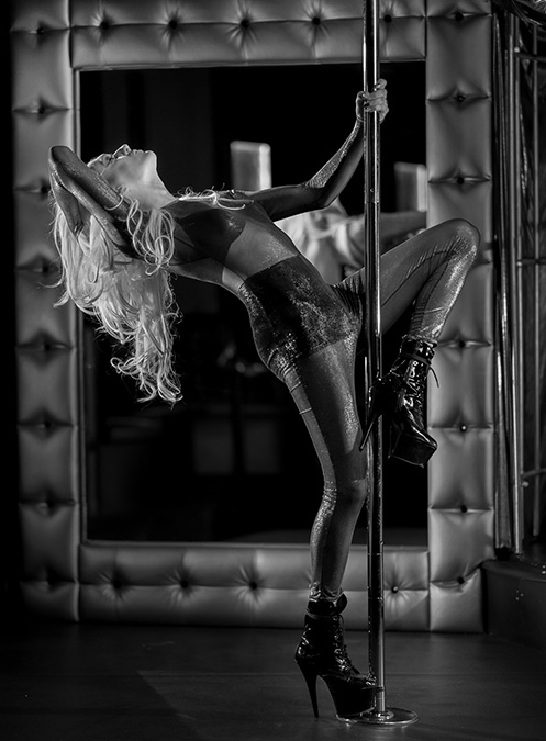 Drag Queen pole dancing black and white photo.