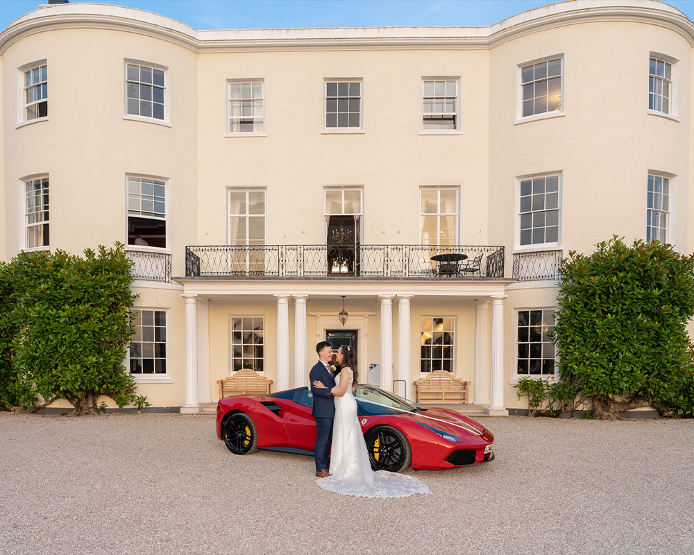 Wedding at Rockbeare Manor with Ferrari parked outside.