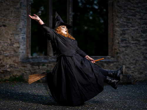 Witch flying on broomstick for Halloween photoshoot.