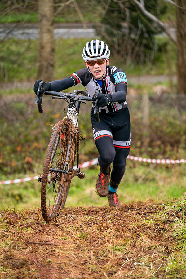 Struggling up a muddy hill during cycle race.