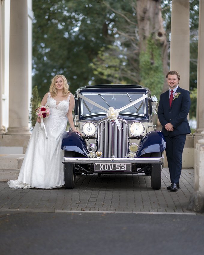 Bride and groom with vintage wedding car at Exeter golf and country club.