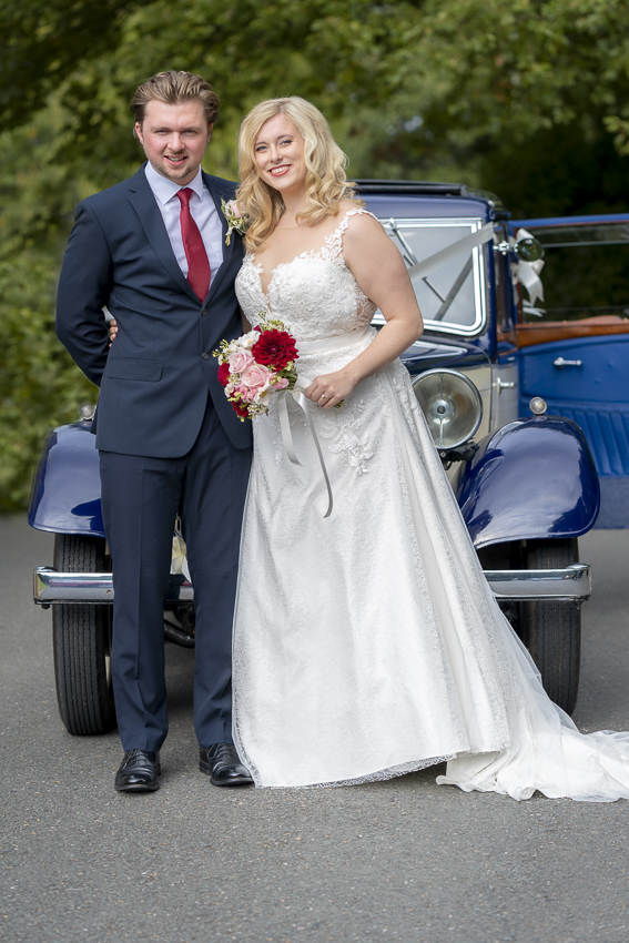 Bride and Groom by vintage wedding car
