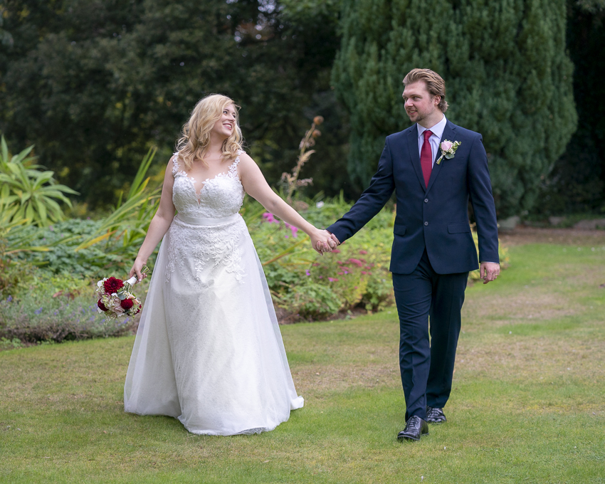 Bride and Groom walking along the grounds of Larkbeare House.