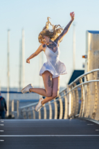 Model jumping in the air on bridge.