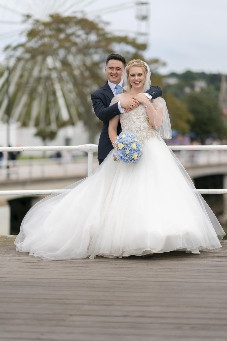 Bride and Groom with Torquay&#039;s big wheel behind them